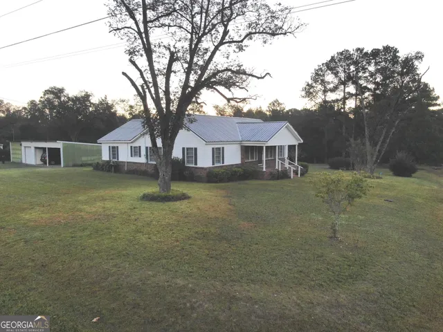a front view of a house with a yard and trees