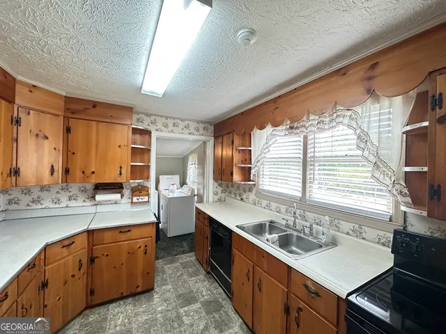 a kitchen with stainless steel appliances sink a stove and cabinets