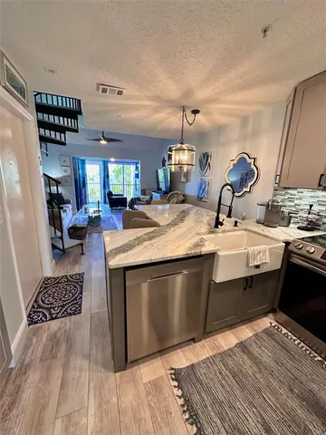 a kitchen with stainless steel appliances granite countertop a sink stove and cabinets