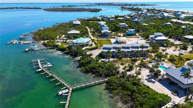 an aerial view of residential houses with outdoor space and lake view