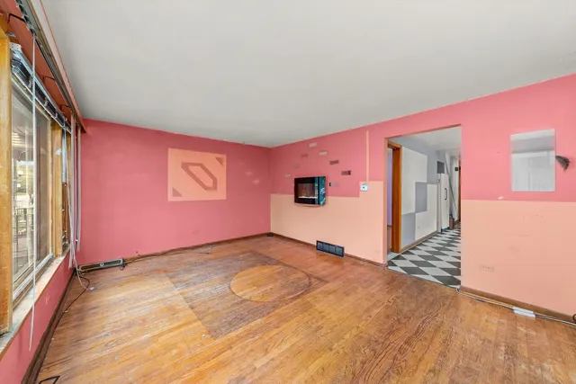 a view of empty room with wooden floor