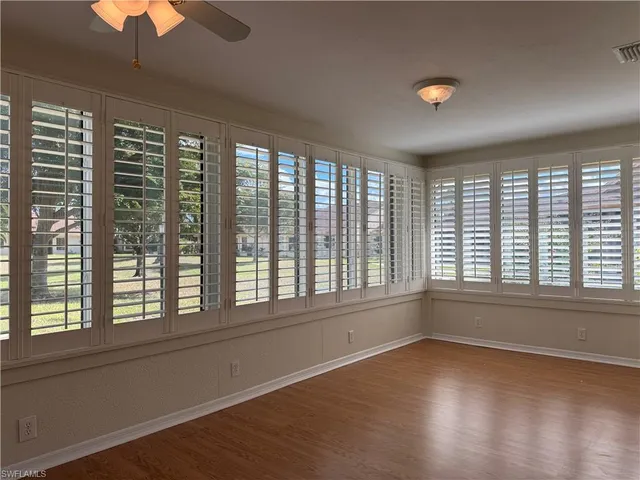 a view of a room with wooden floor and a ceiling fan