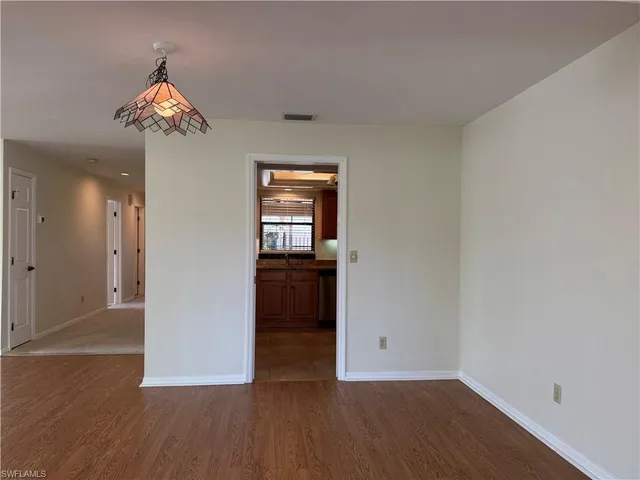 a bedroom with a bed a dresser and a chandelier