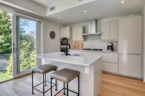 a kitchen with stainless steel appliances granite countertop a sink a stove a refrigerator and cabinets