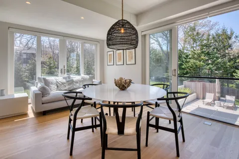 a dining room with furniture window and wooden floor