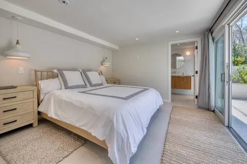 a bedroom with a bed and a large mirror