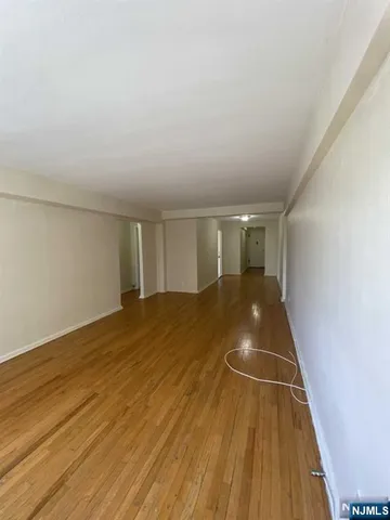 a view of a room with wooden floor and white walls