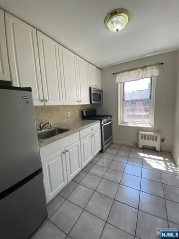 a kitchen with stainless steel appliances a sink a stove a microwave and cabinets
