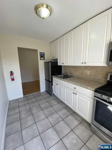 a kitchen with a sink a stove cabinets and utility