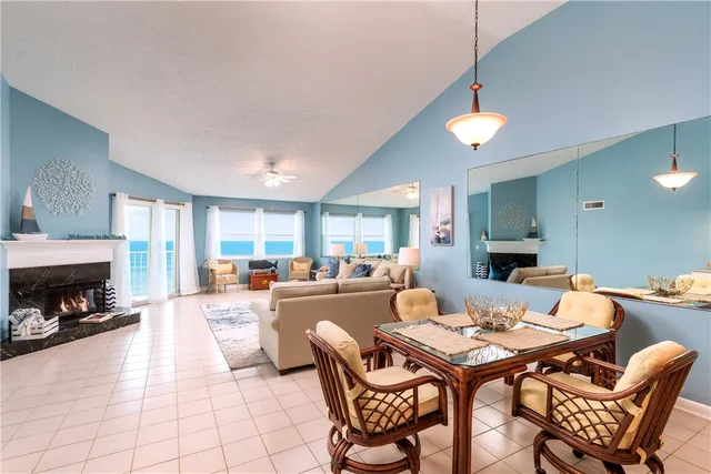 a dining room with furniture a fireplace and large window