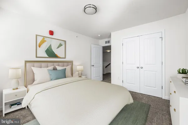 a bedroom with a bed and a painting on the wall