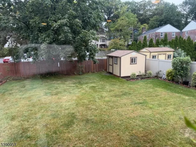 a view of a house with a yard and fence