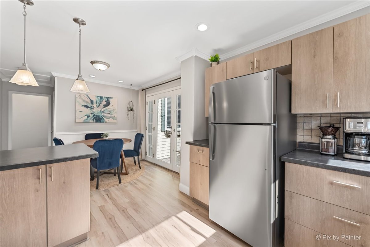 116 Deerpath Road Lake In The Hills, IL 60156 - Photo 13 of 33 a kitchen with stainless steel appliances granite countertop a refrigerator a sink a dining table and chairs with wooden floor