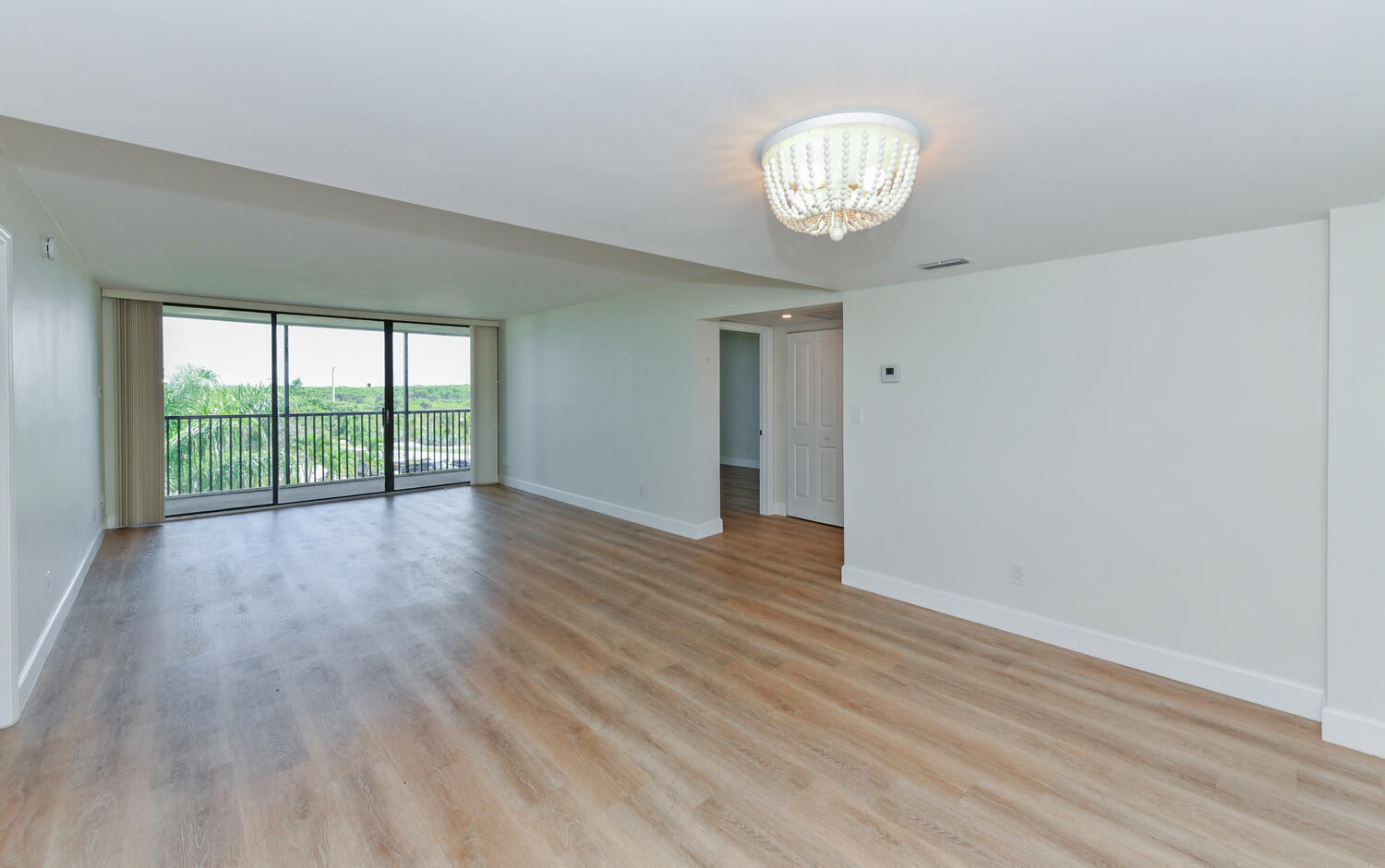 1605 Highway 1, Unit M1403 Jupiter, FL 33477 - Photo 5 of 34 a view of an empty room with wooden floor and a window