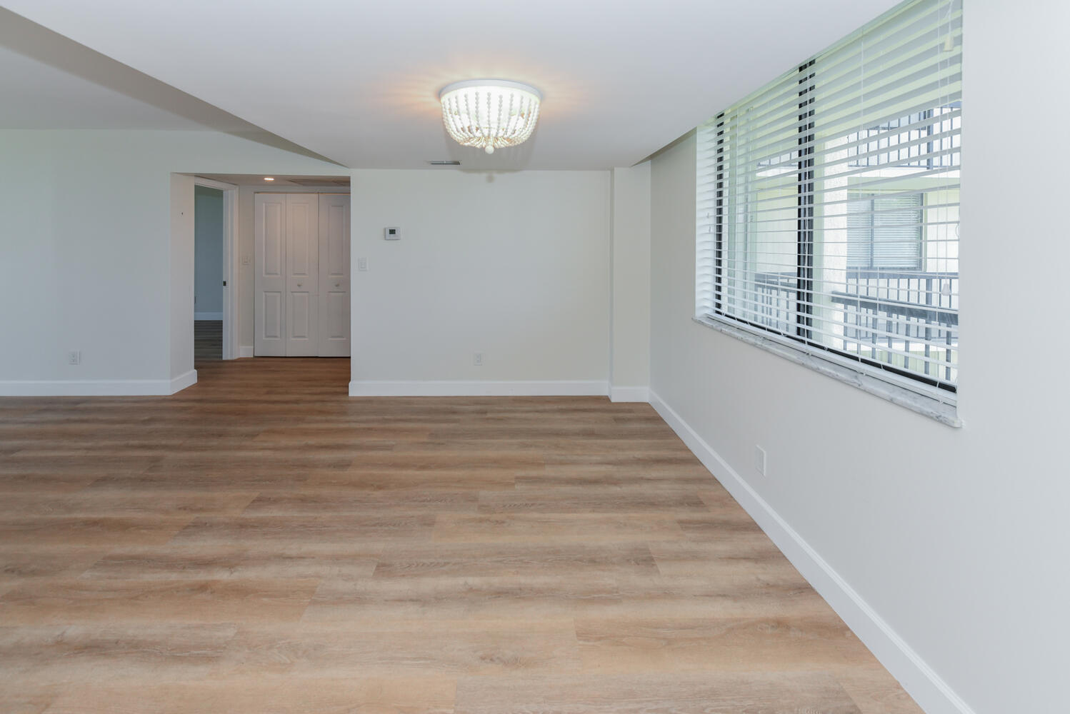 1605 Highway 1, Unit M1403 Jupiter, FL 33477 - Photo 8 of 34 a view of an empty room with wooden floor and a window