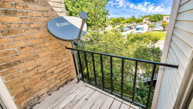 a view of a balcony with wooden floor and fence