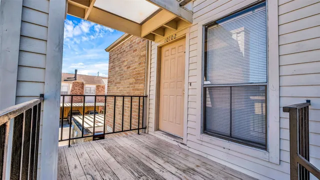 a view of pool with lawn chairs and large trees