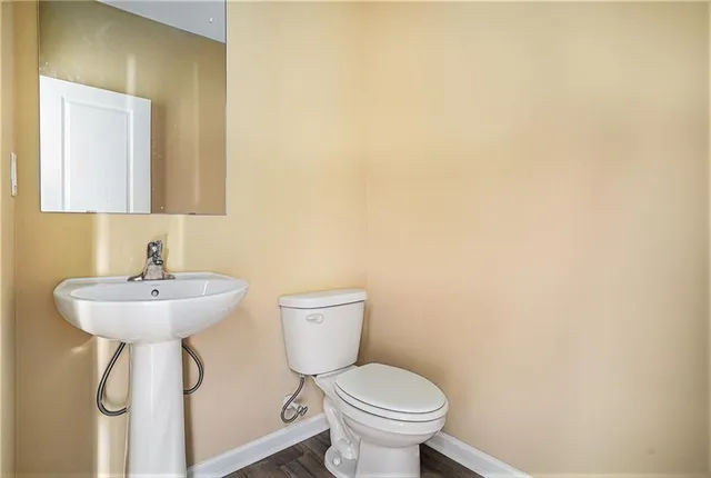 a bathroom with a sink a toilet and mirror