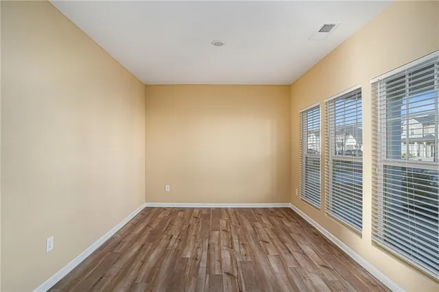 a view of a room with wooden floor and a window