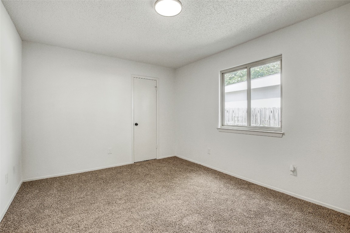 902 King Albert Street, Unit A Austin, TX 78745 - Photo 16 of 19 Carpeted empty room featuring a textured ceiling and baseboards