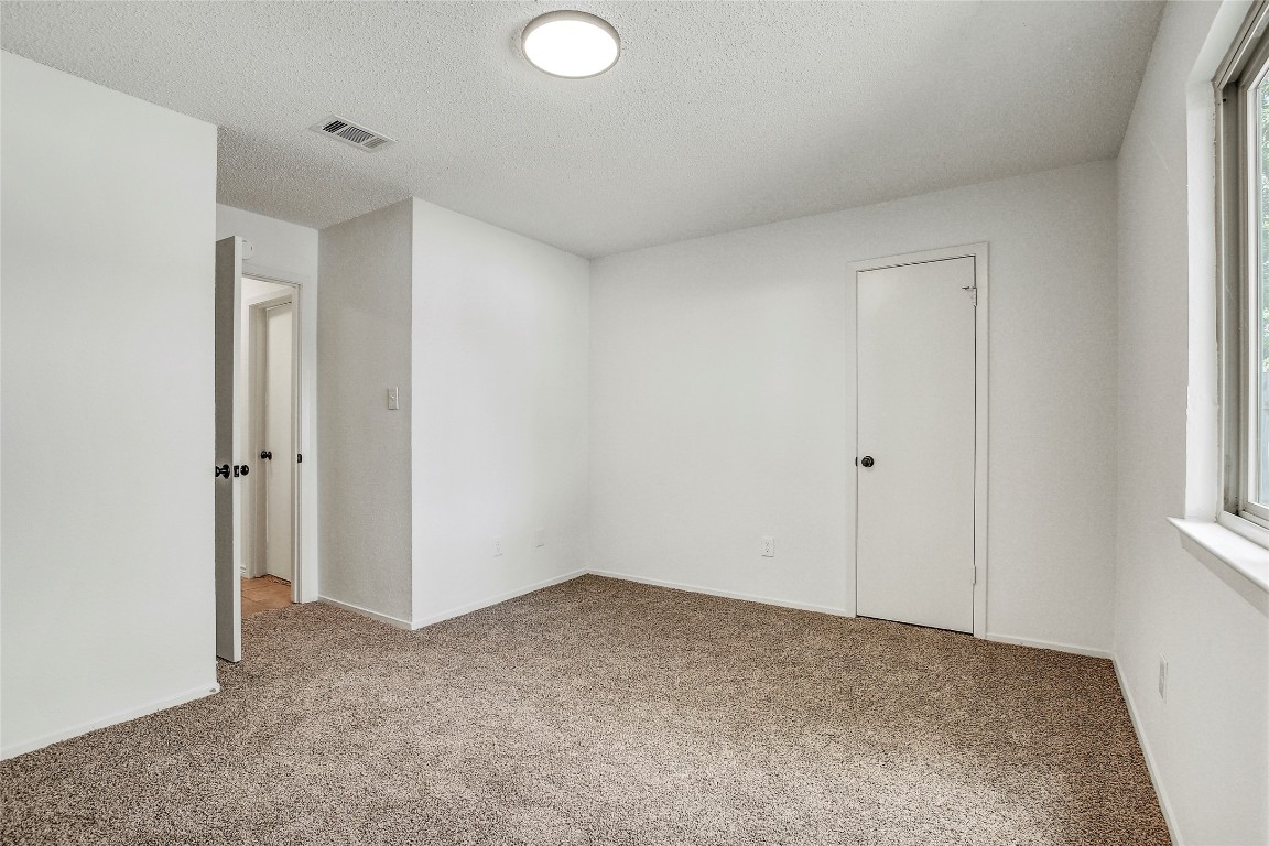 902 King Albert Street, Unit A Austin, TX 78745 - Photo 17 of 19 Unfurnished room with carpet flooring and a textured ceiling