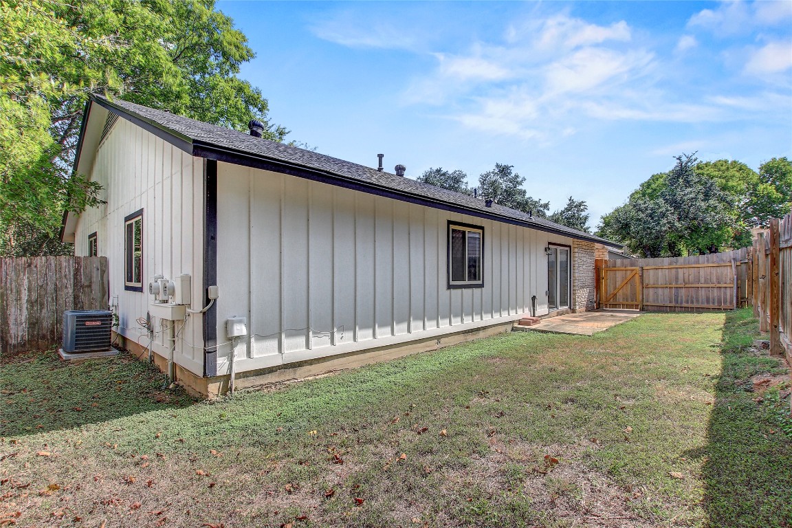 902 King Albert Street, Unit A Austin, TX 78745 - Photo 19 of 19 Rear view of property featuring a gate, a fenced backyard, board and batten siding, and roof with shingles