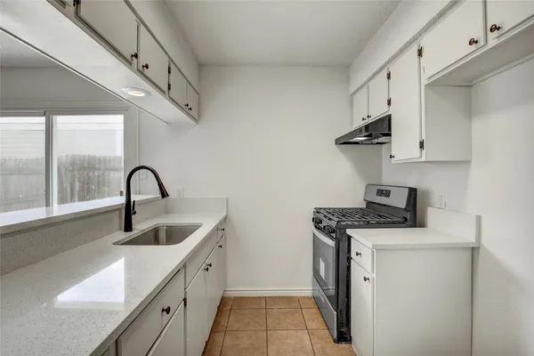 a kitchen with stainless steel appliances granite countertop a sink and a stove