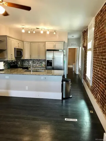 a kitchen with stainless steel appliances wooden cabinets a refrigerator and a sink