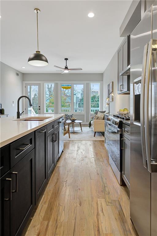 454 Connally Street Southeast Atlanta, GA 30312 - Photo 9 of 32 a open kitchen with stainless steel appliances granite countertop a stove a sink dishwasher a refrigerator and a dining table with wooden floor