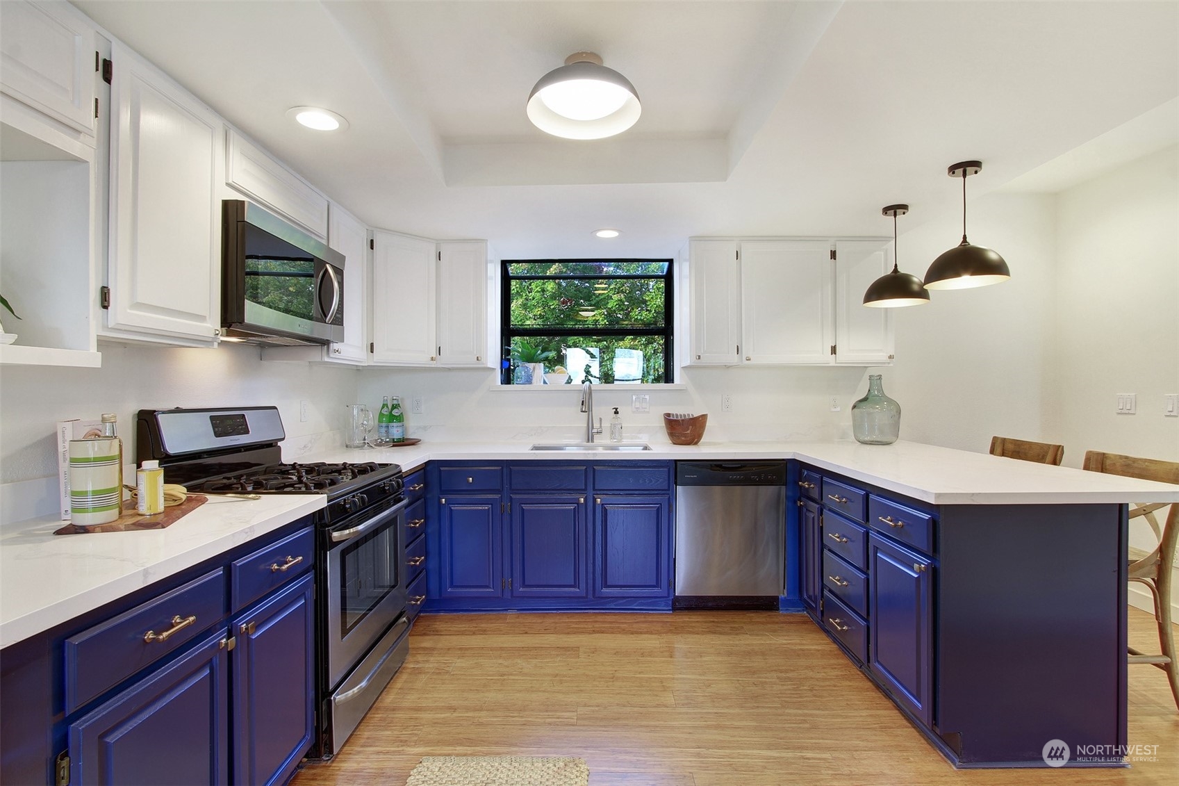 323 Northeast 76th Street Seattle, WA 98115 - Photo 11 of 33 a kitchen with stainless steel appliances granite countertop wooden cabinets sink stove and microwave