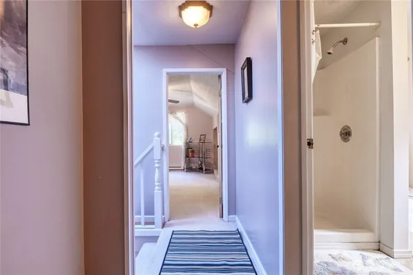 a view of a hallway with wooden floor and living room