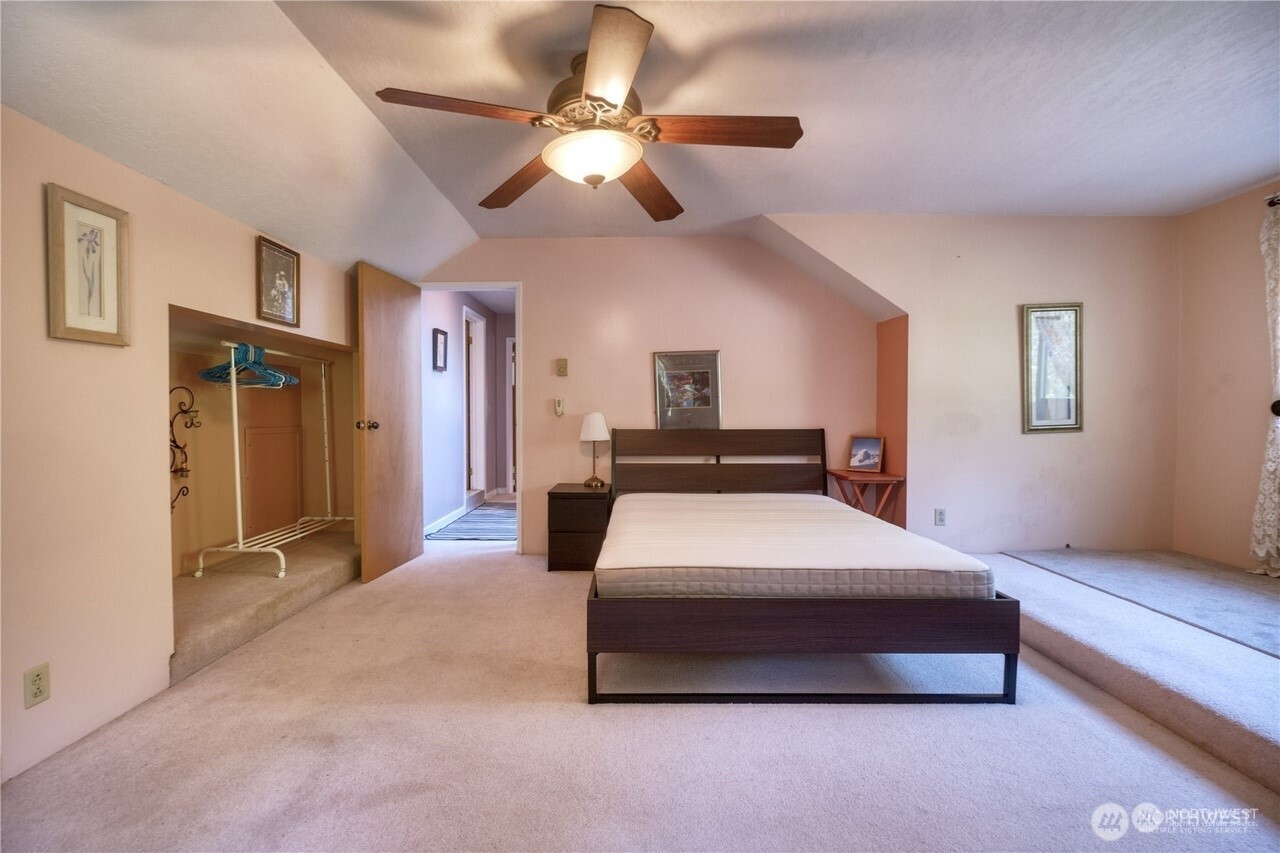 1857 Washington Drive Point Roberts, WA 98281 - Photo 20 of 38 a spacious bedroom with a bed and a chandelier