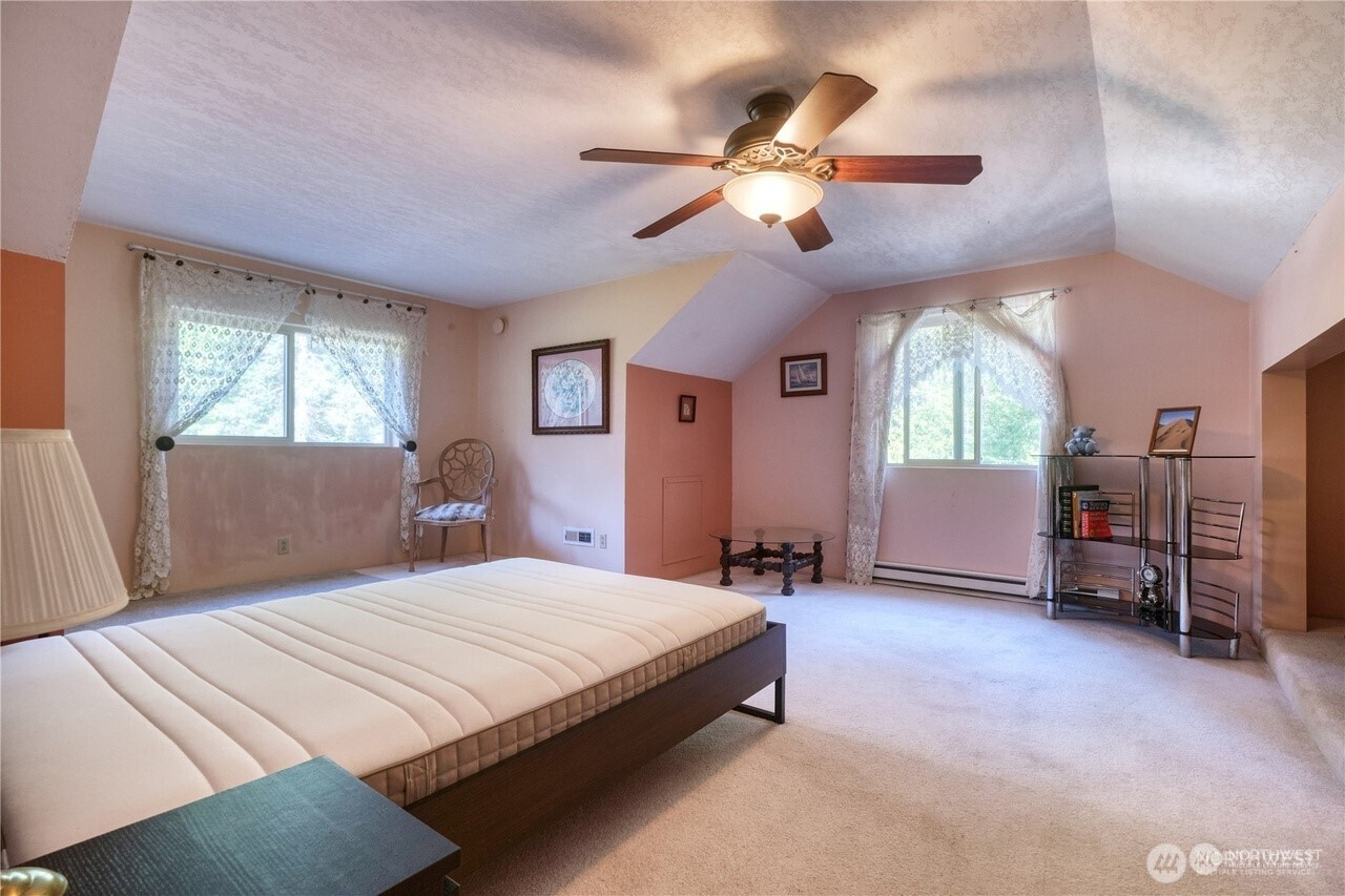 1857 Washington Drive Point Roberts, WA 98281 - Photo 21 of 38 a spacious bedroom with a large bed and a chandelier