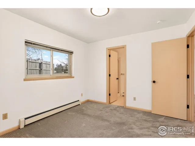 a view of an empty room with window and closet area