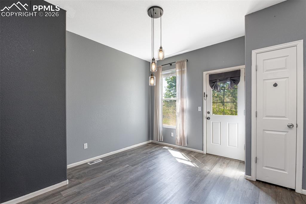 7740 Sandy Springs Point Fountain, CO 80817 - Photo 13 of 34 Unfurnished dining area with baseboards and wood finished floors