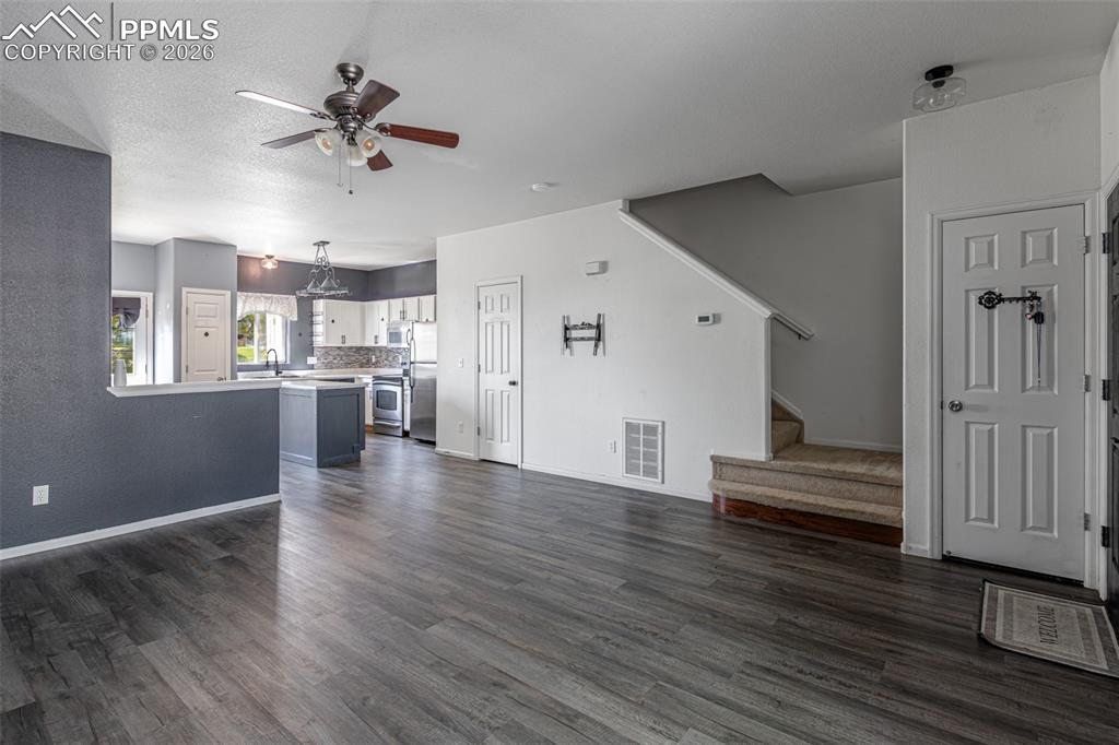 7740 Sandy Springs Point Fountain, CO 80817 - Photo 6 of 34 Unfurnished living room featuring a ceiling fan and dark wood-style floors