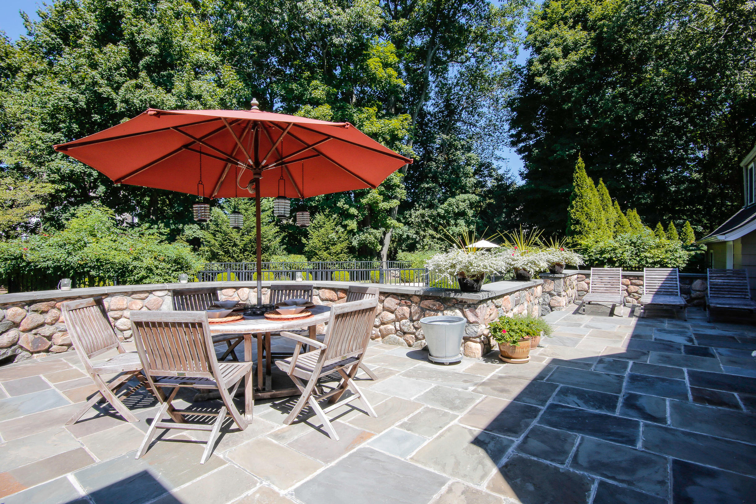 21 Old Studio Road New Canaan, CT 06840 - Photo 12 of 39 a view of a patio with table and chairs under an umbrella