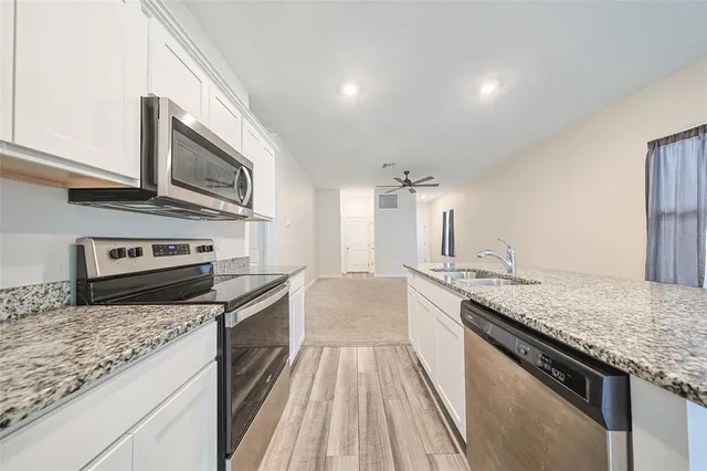 a kitchen with stainless steel appliances granite countertop a stove and a sink