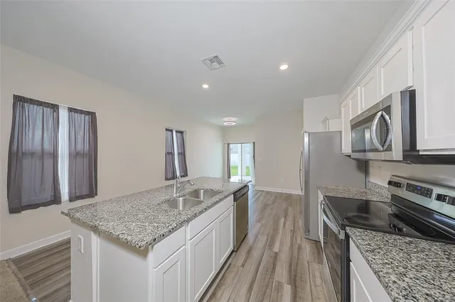 a kitchen with stainless steel appliances granite countertop a sink stove and cabinets