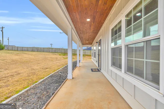 a view of a kitchen from the hallway with a sink and wooden floor