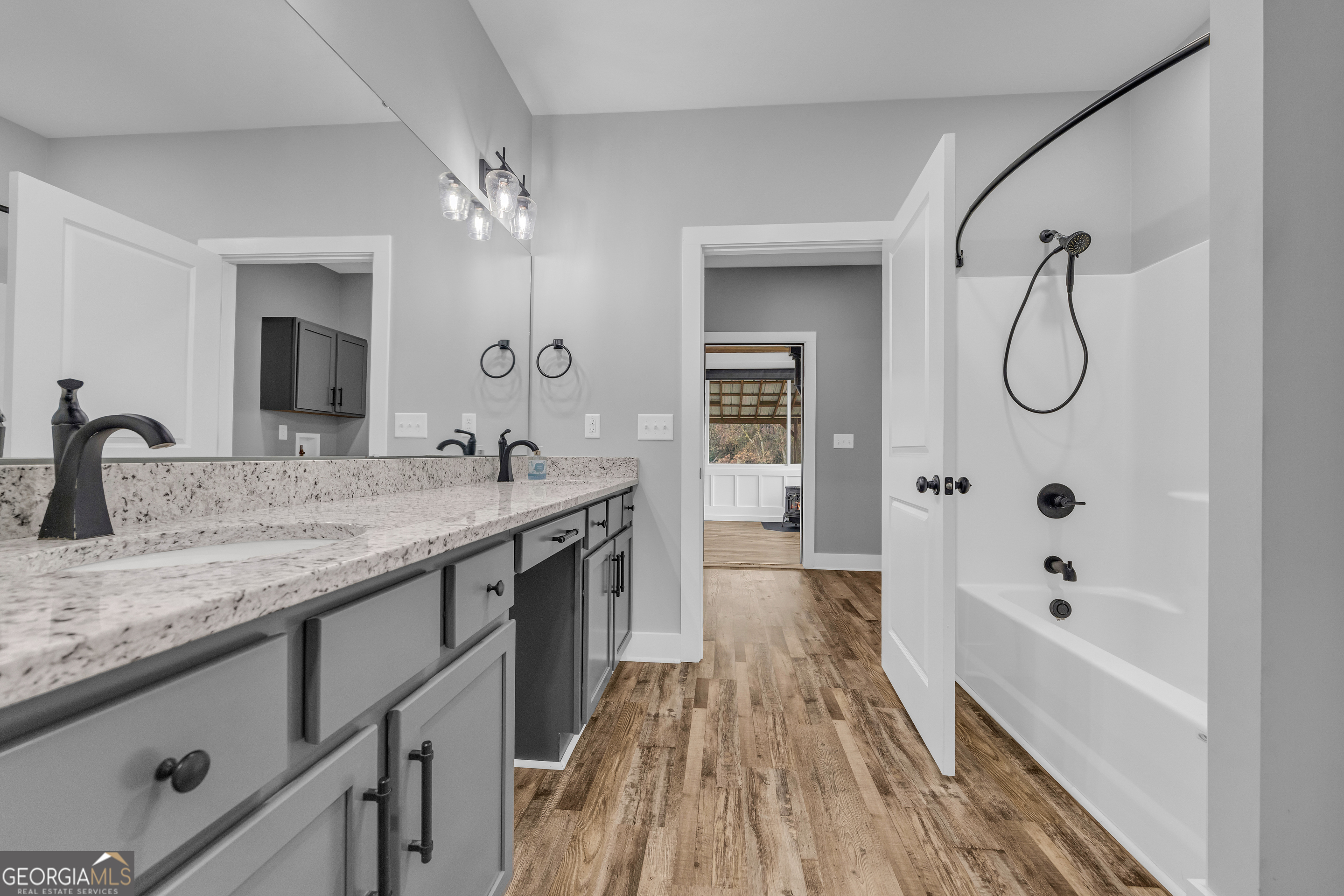 5177 Sandy Cross Road Carnesville, GA 30521 - Photo 65 of 86 a spacious bathroom with a granite countertop sink a mirror a bathtub and shower