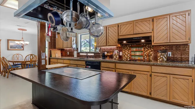 a kitchen with stainless steel appliances granite countertop a sink a stove and white cabinets