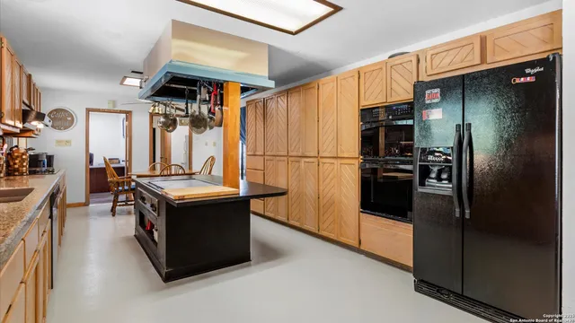 a kitchen with refrigerator and cabinets
