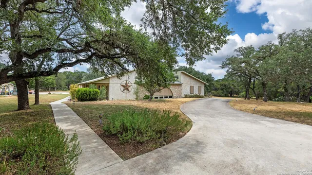 a front view of a house with a yard and trees