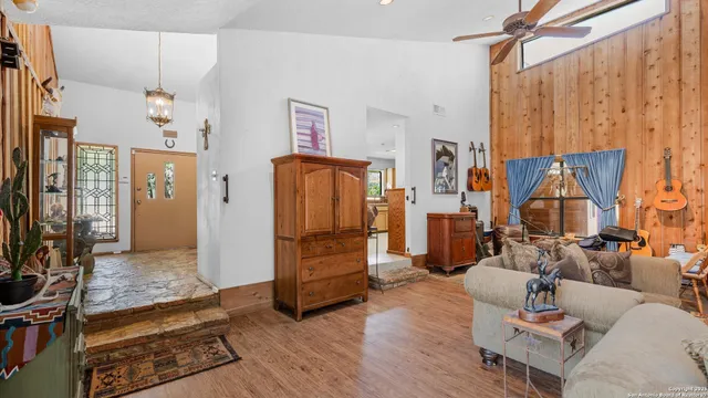 a living room with furniture a flat screen tv and a refrigerator