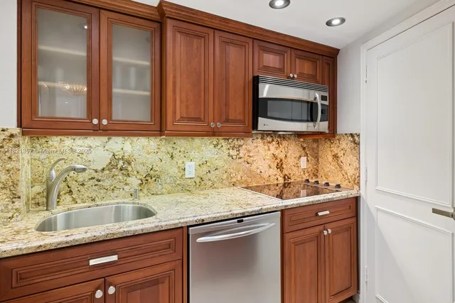 a kitchen with granite countertop stainless steel appliances a stove sink and microwave