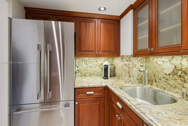 a kitchen with granite countertop a refrigerator and a sink