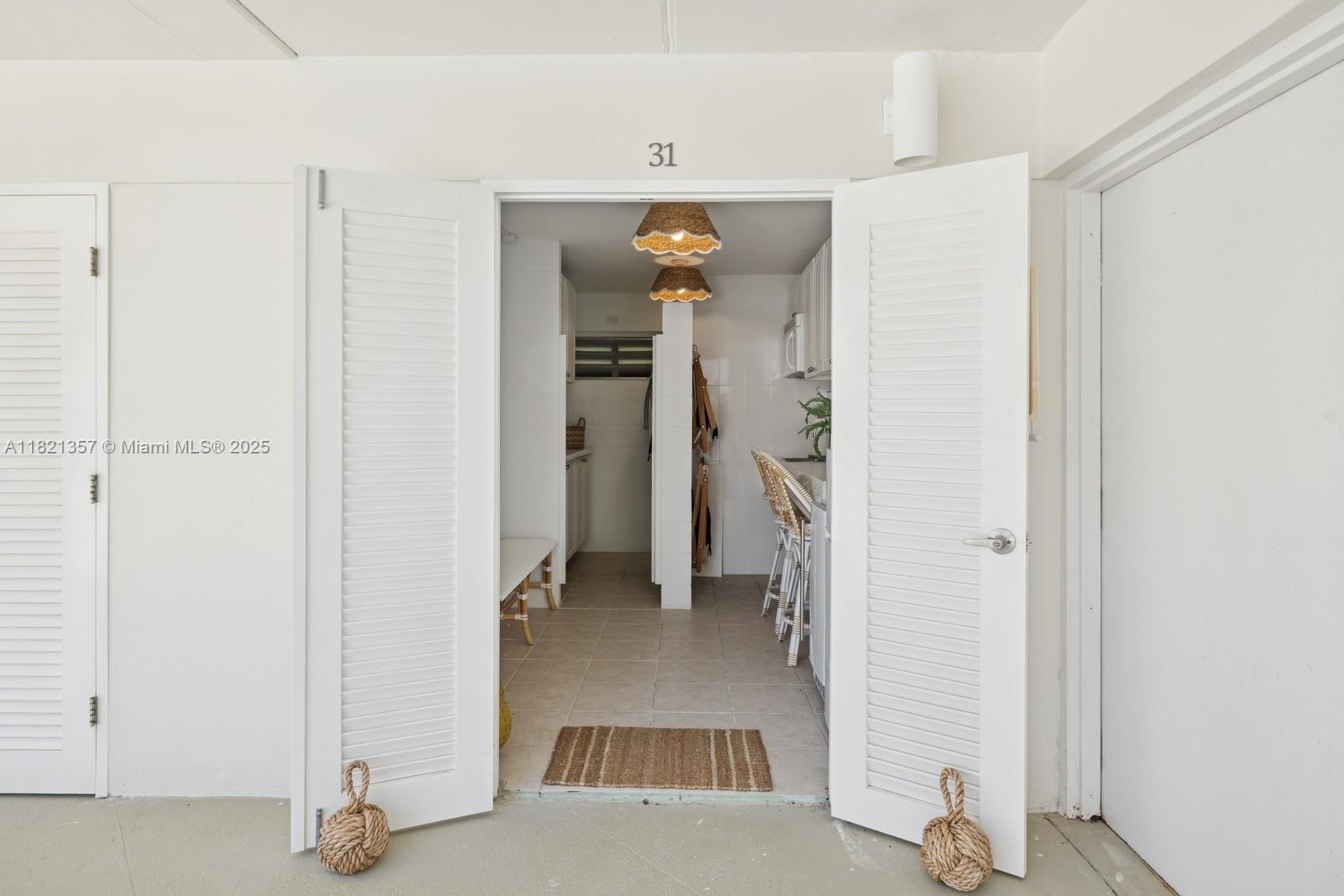 2899 Collins Avenue, Unit 1025 Miami Beach, FL 33140 - Photo 16 of 19 a view of a hallway with closet and a living room