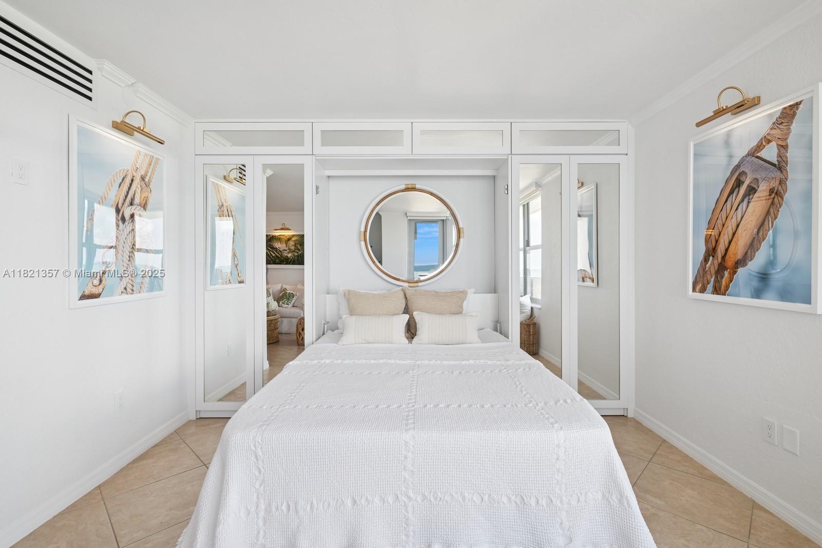 2899 Collins Avenue, Unit 1025 Miami Beach, FL 33140 - Photo 3 of 19 a bedroom with a bed and a mirror