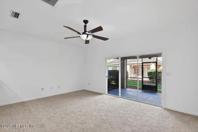 an empty room with a window and a ceiling fan